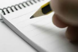 Imagen de una mano escribiendo con un lápiz en una libreta